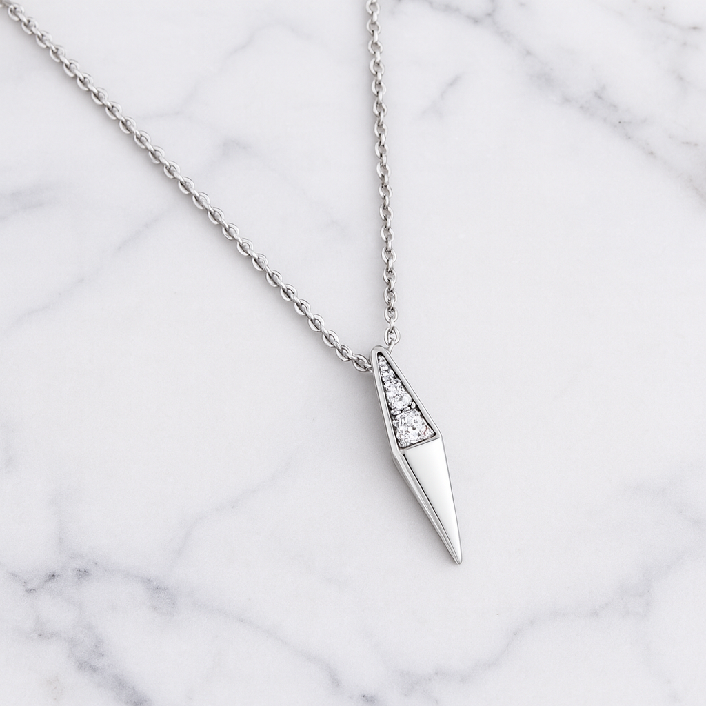 Silver necklace with a geometric pendant on a marble background