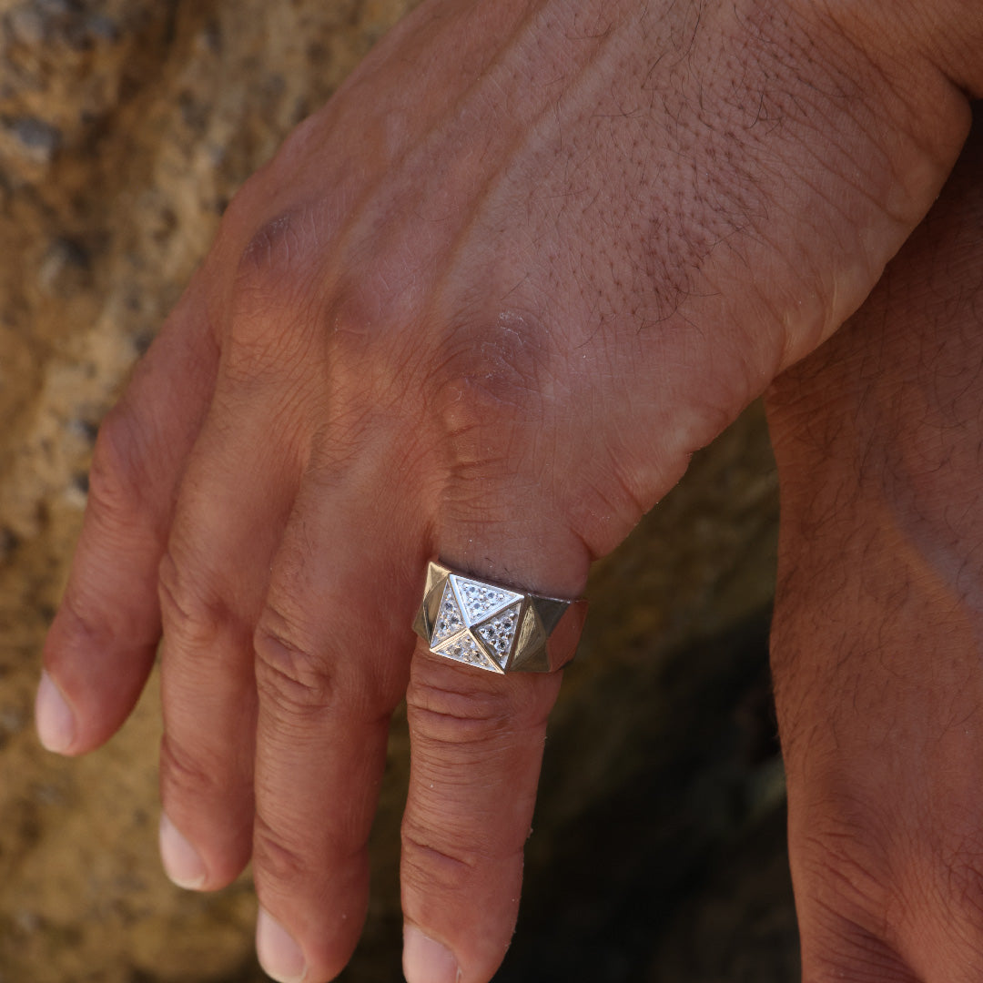 Sterling silver ring with pyramid design on a hand, featuring gemstone accents.