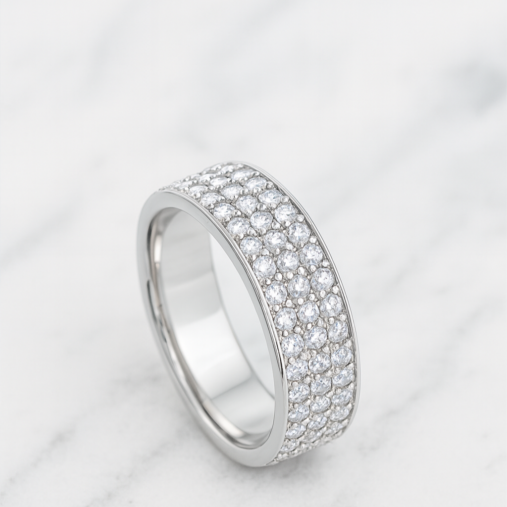 Silver ring with embedded stones on a white marble surface