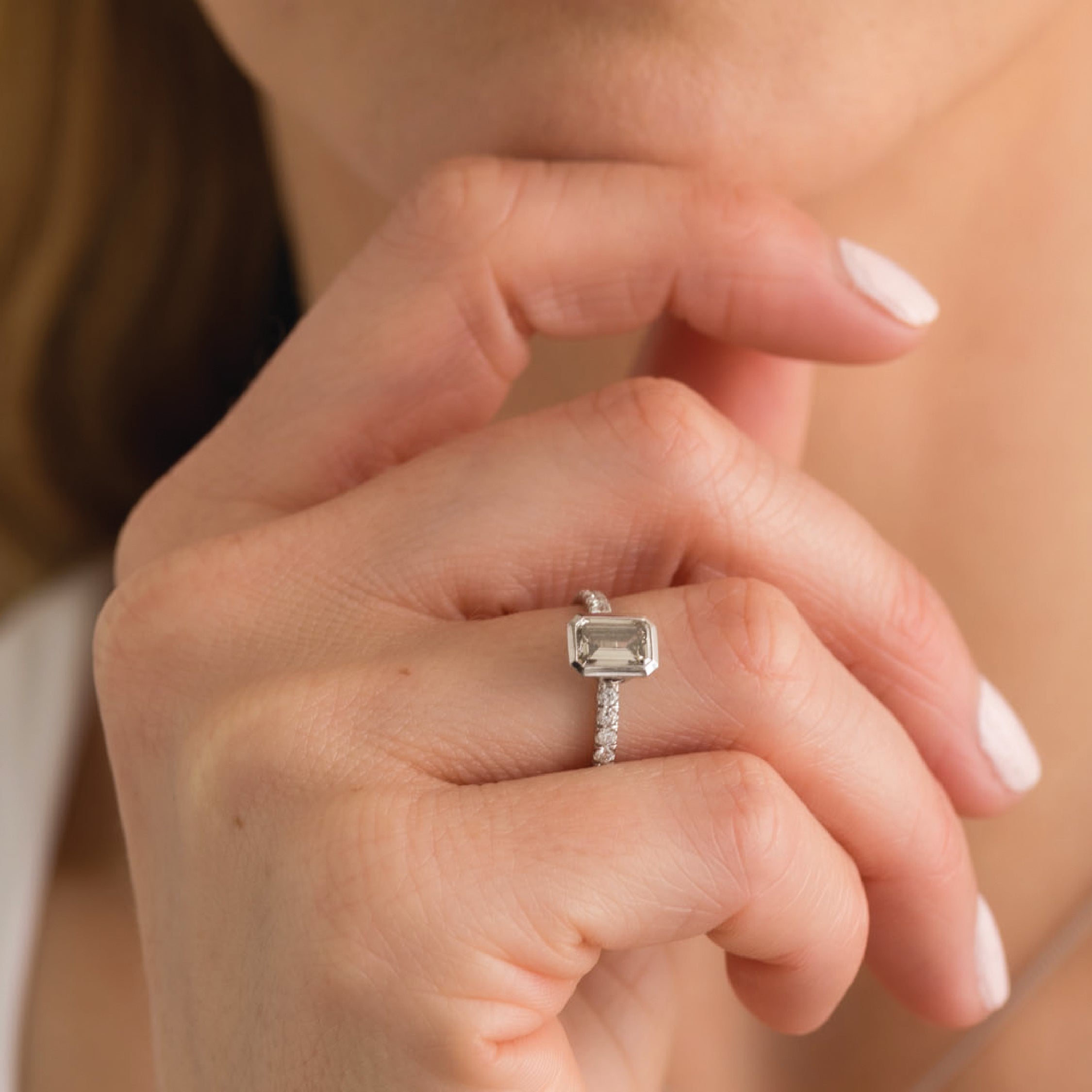 Close-up of a hand wearing a white gold ring with a smokey gemstone.