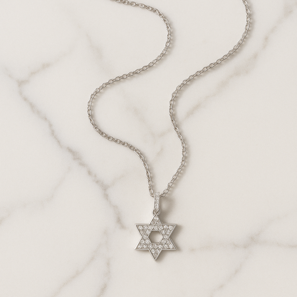 Silver necklace with a Star of David pendant on a light marble background