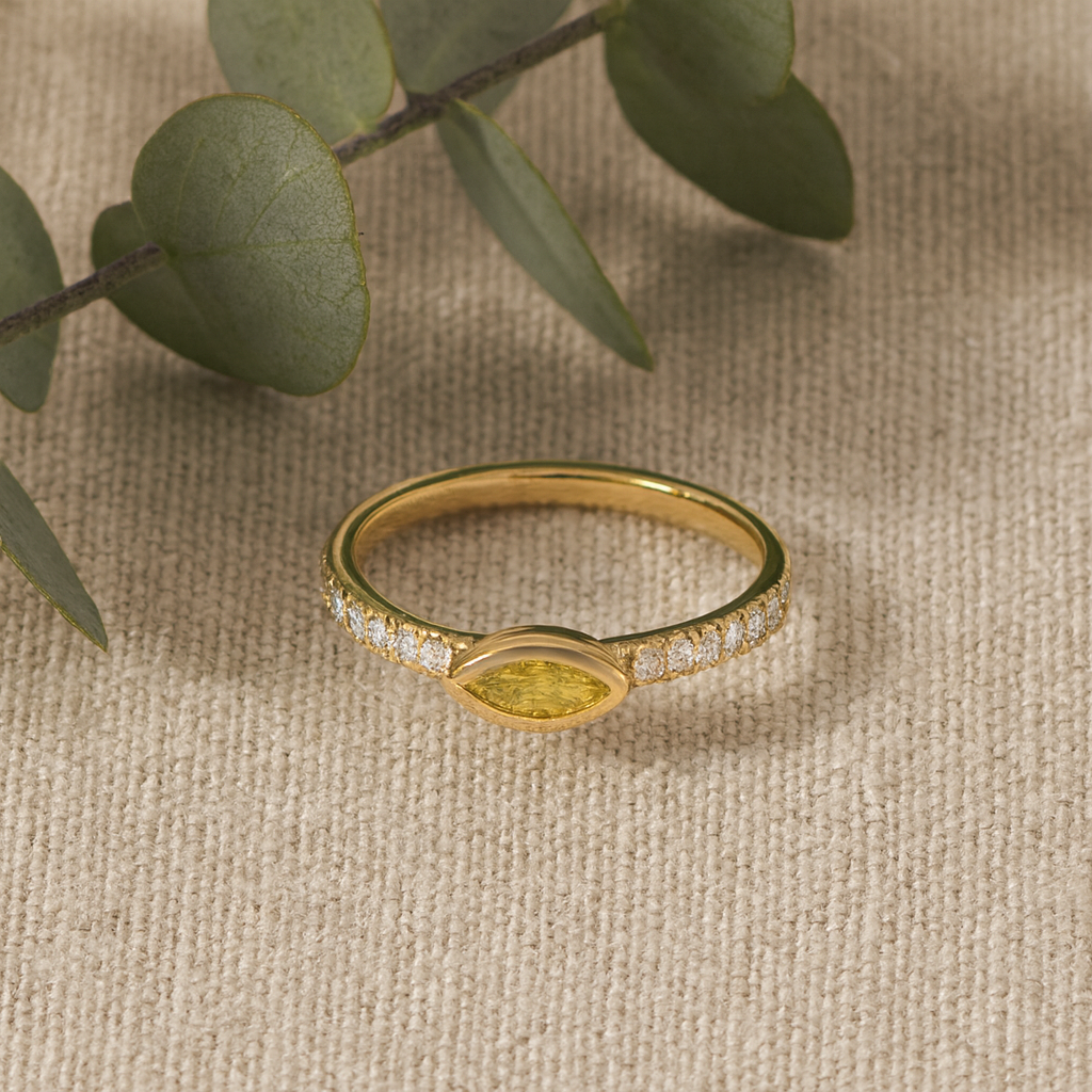 Gold ring with gemstone on a beige fabric background