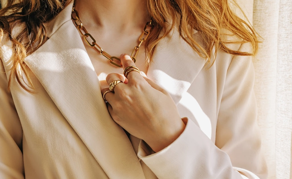 A women wearing a paperclip necklace while slightly touching it 
