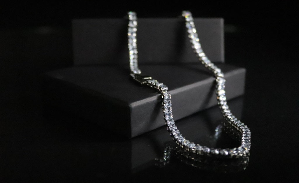 Sterling Silver Sapphire Cable Chain laying on a black box 