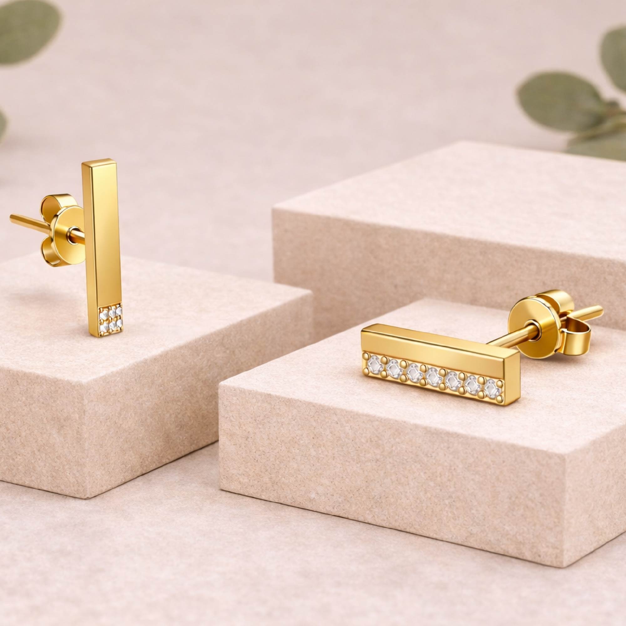 Gold bar earrings with embedded diamonds on a beige display stand.