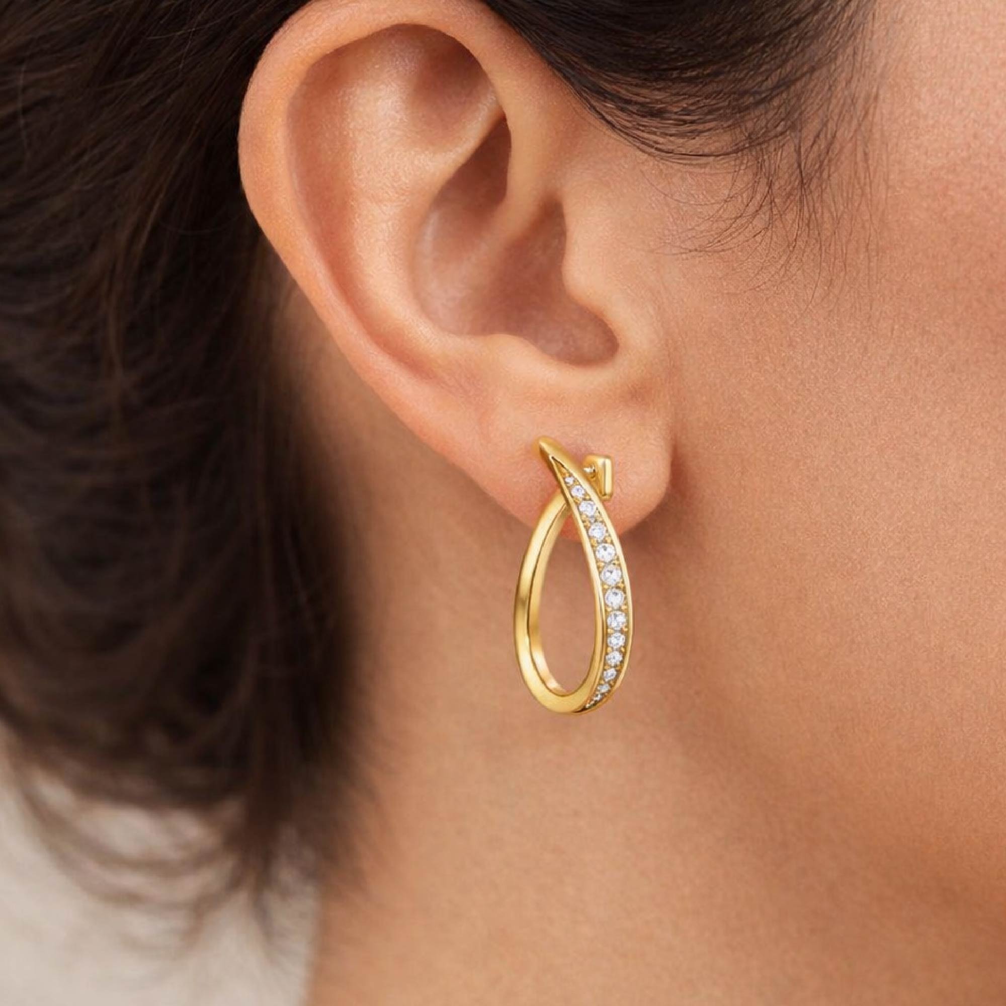 Gold hoop earring with diamonds on an ear