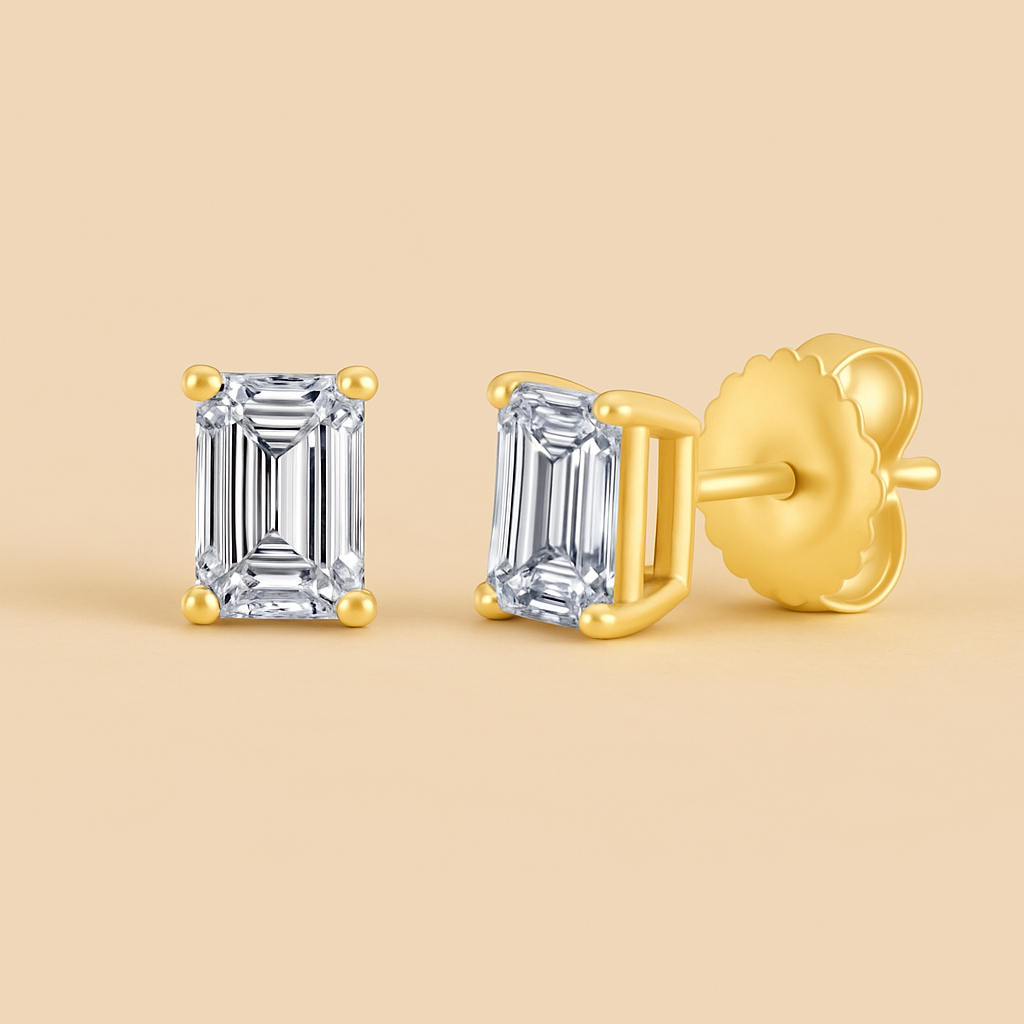 Gold emerald-cut diamond earrings on a beige background
