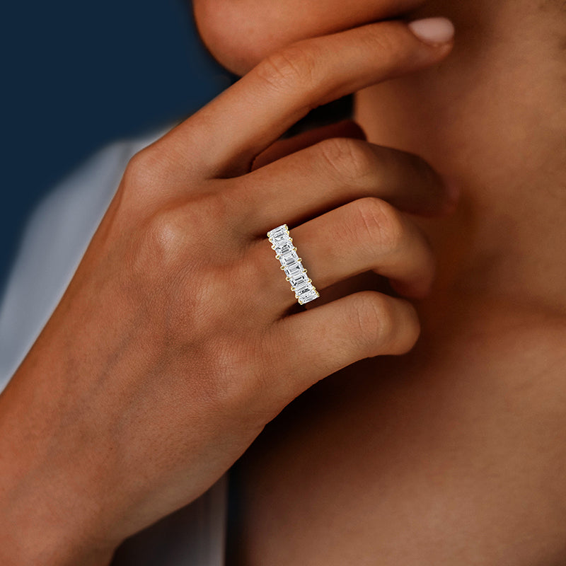 Close-up of a hand wearing a diamond ring with a blurred background