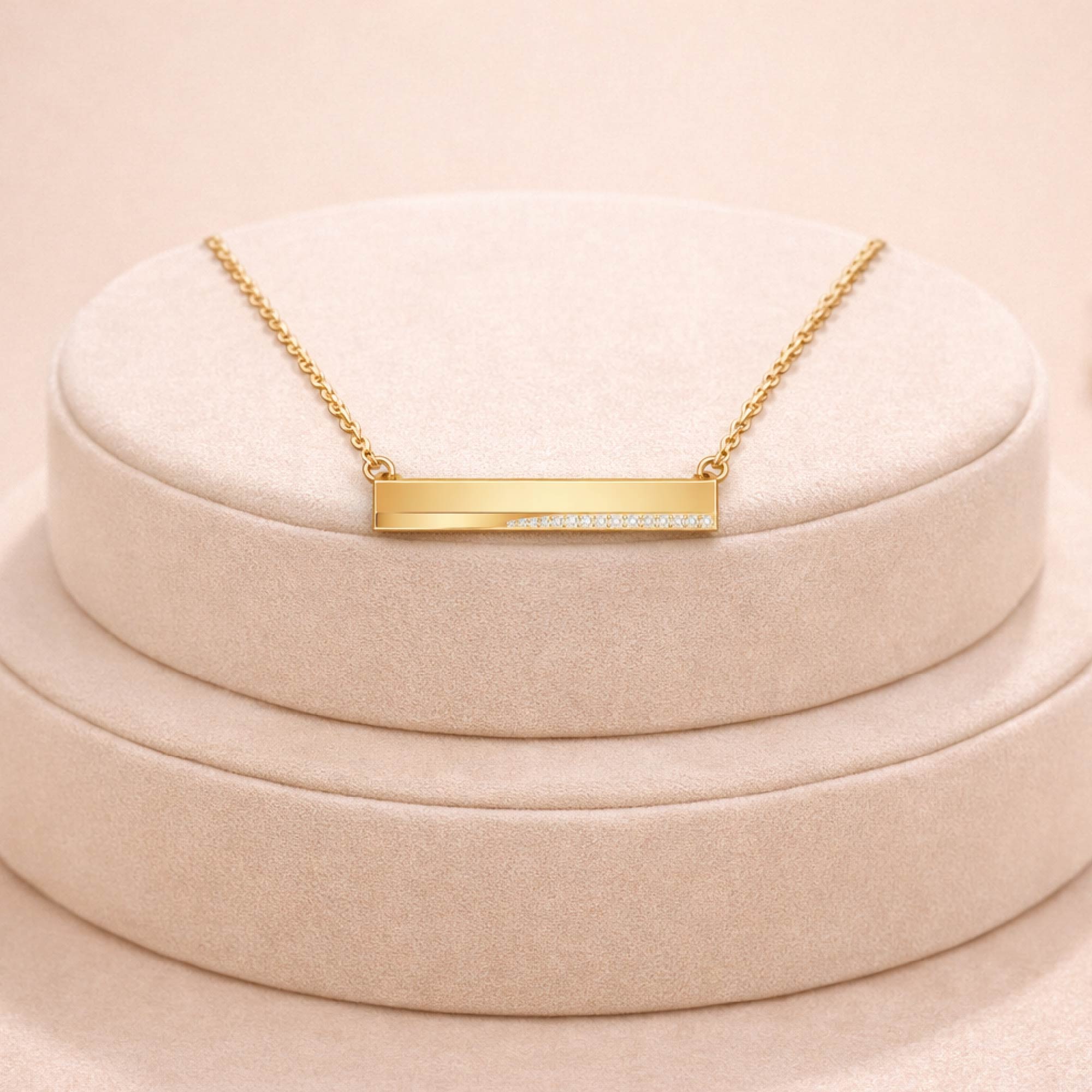 Gold necklace with a bar pendant on a beige cushion