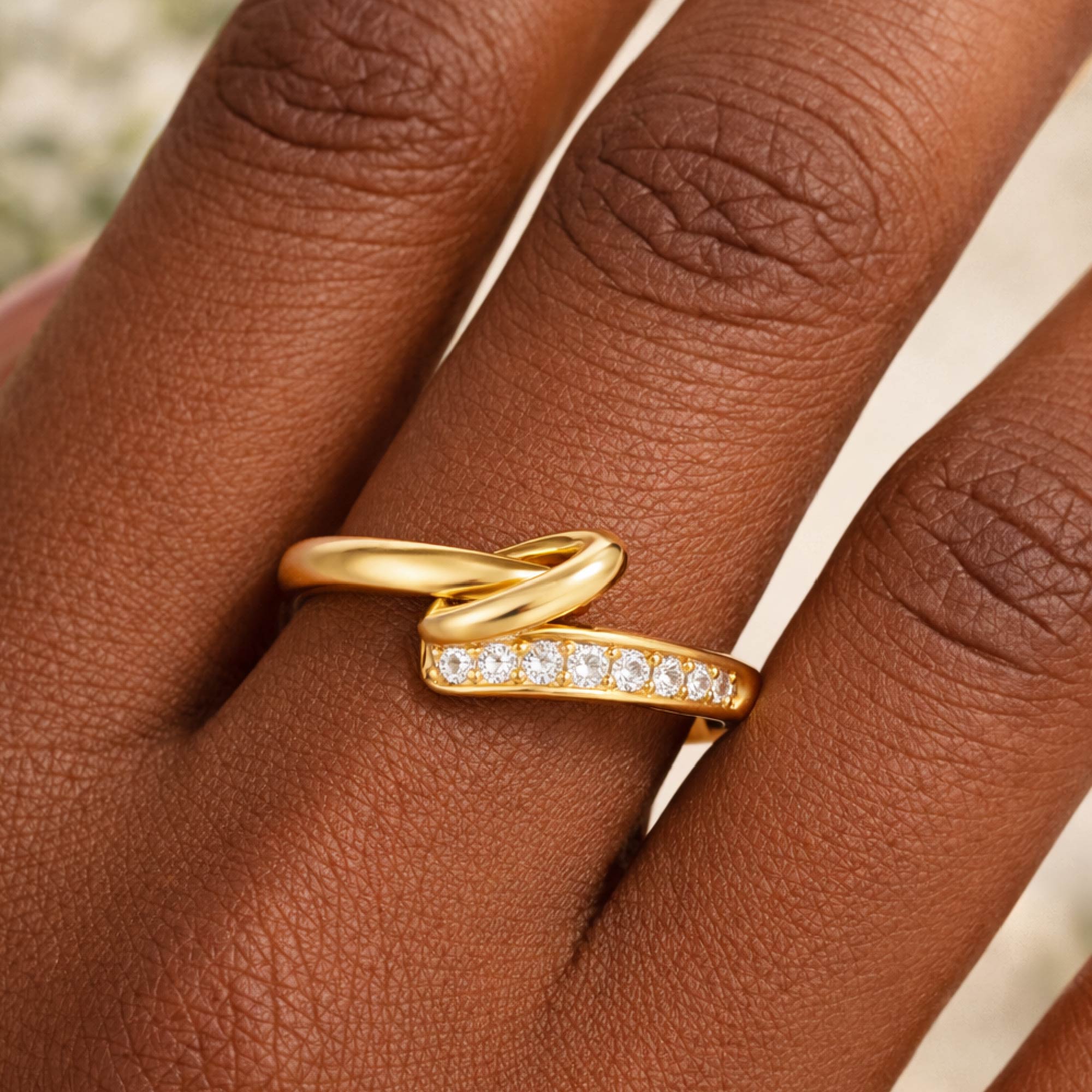 Gold ring with diamonds on a person's finger