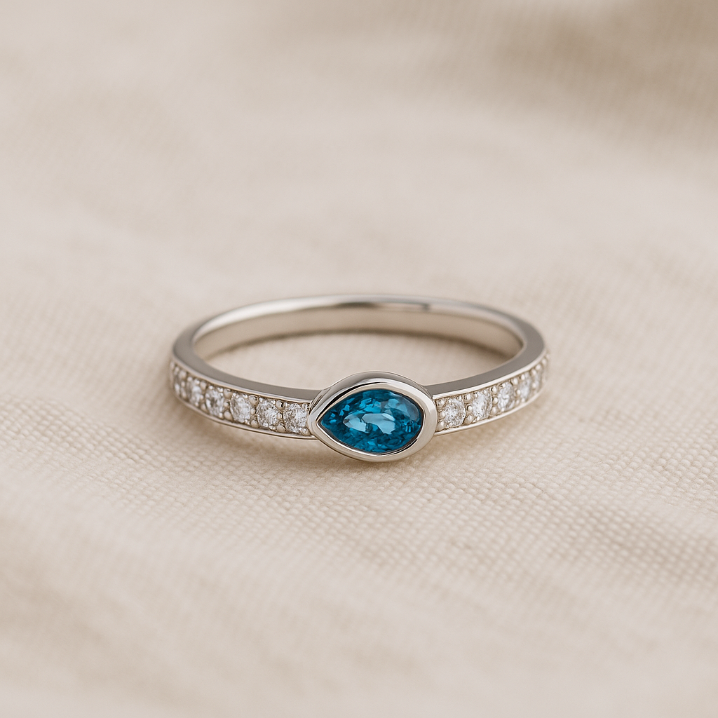 Silver ring with a blue gemstone on a beige fabric background
