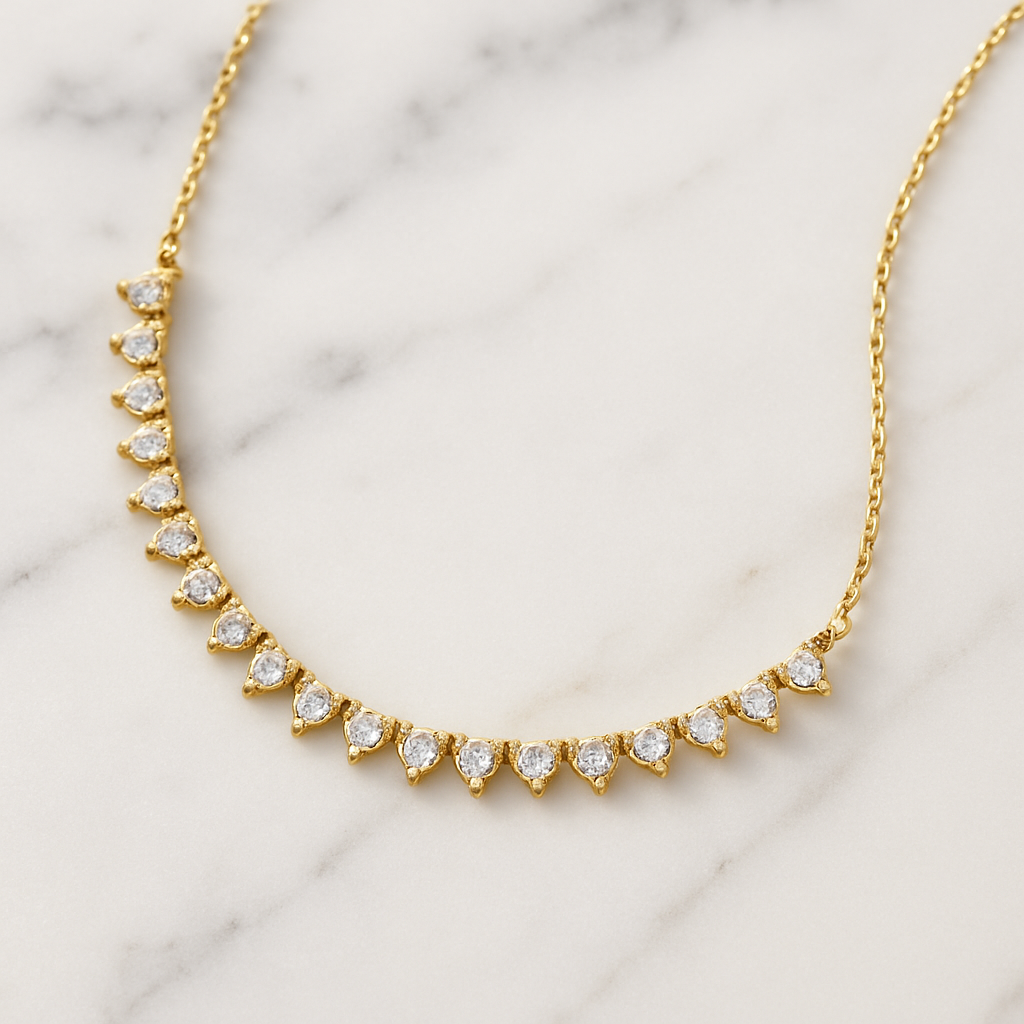 Gold necklace with diamond-like stones on a marble background