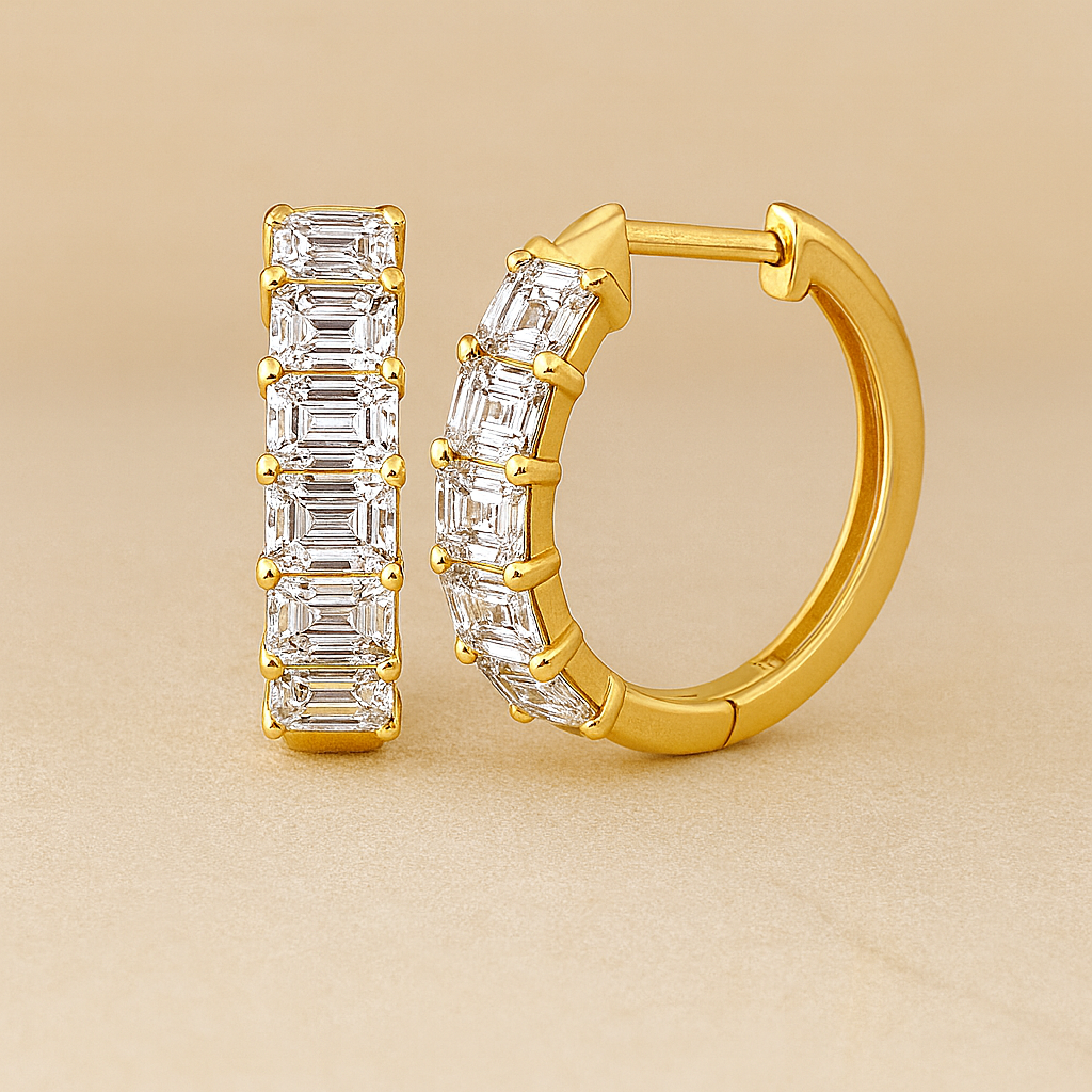 Gold hoop earrings with emerald-cut gemstones on a beige background