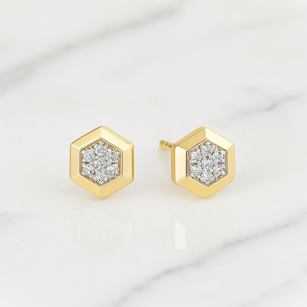 Hexagonal gold earrings with diamond accents on a light gray background