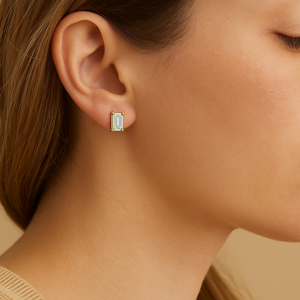 Gold earring worn by a person with a neutral background