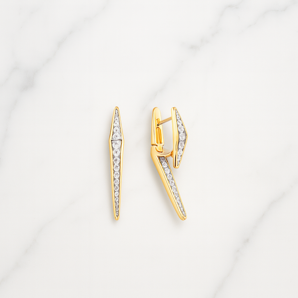Gold earrings with diamond accents on a light gray background
