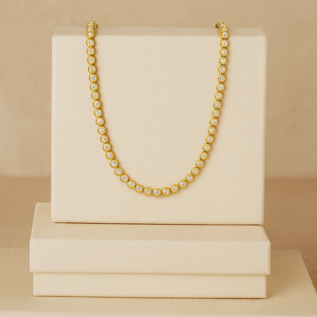 Gold chain necklace on a stack of cream-colored boxes against a beige background