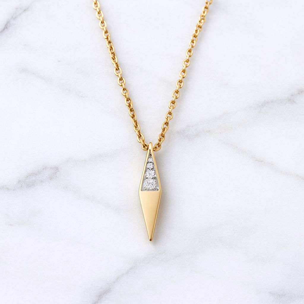Gold necklace with a diamond pendant on a marble background