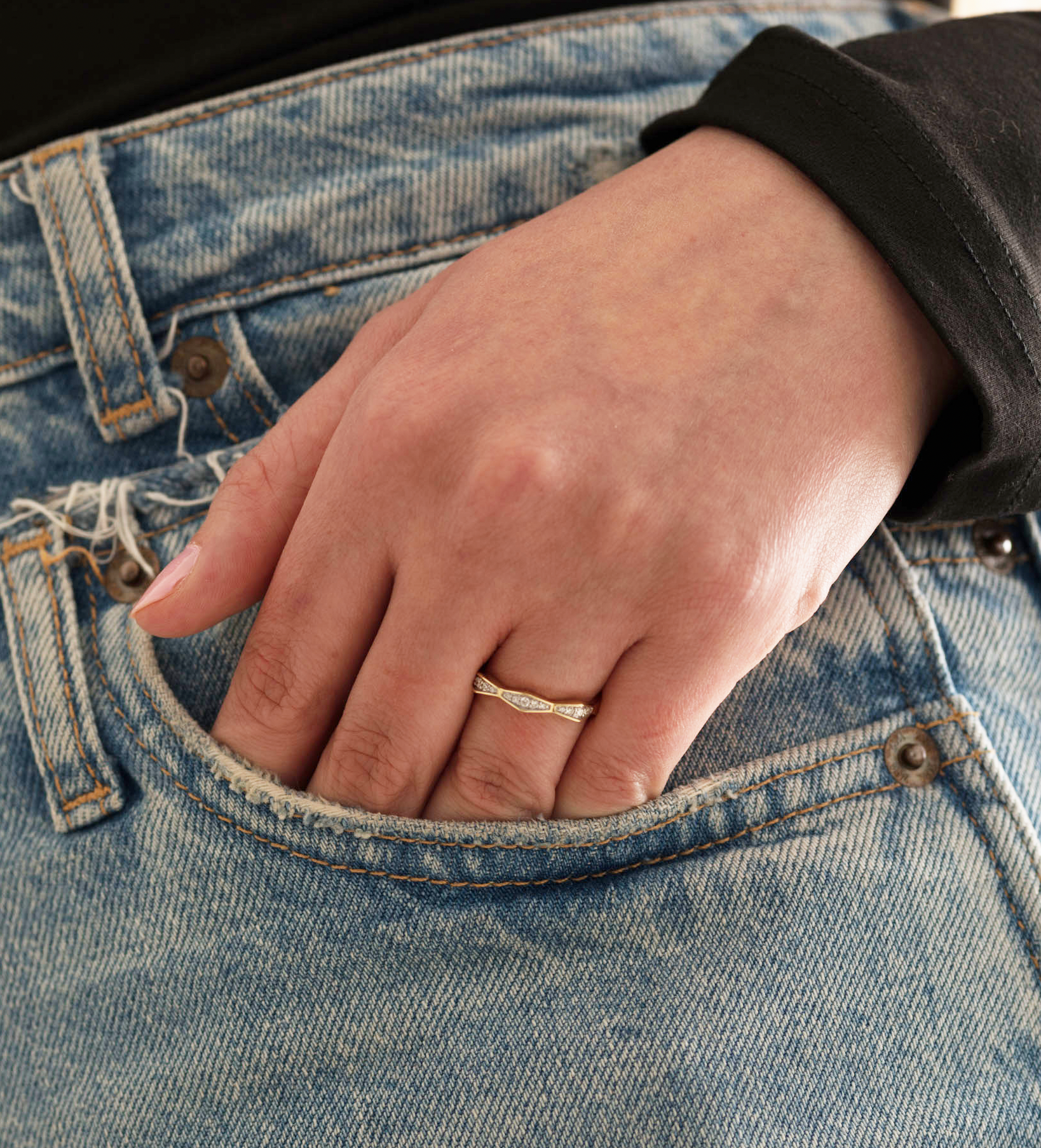 14K solid gold diamond ring on hand in denim pocket, elegant and stylish.