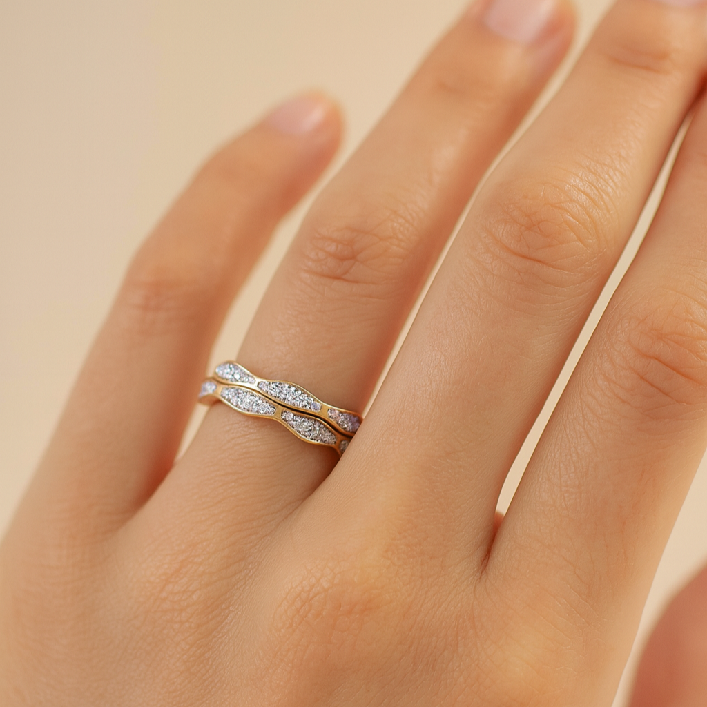 Hand wearing a silver ring with a diamond band on a beige background