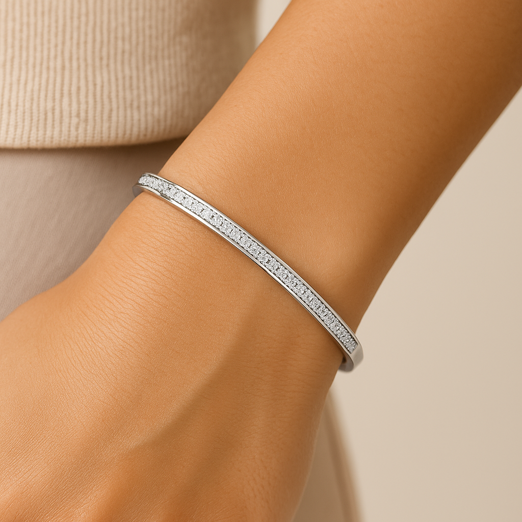 Silver bracelet on a wrist with a neutral background