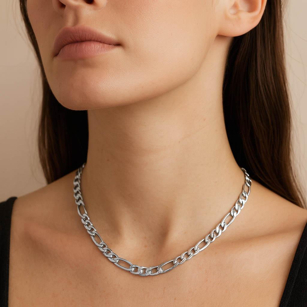 Silver chain necklace worn by a person with a neutral background