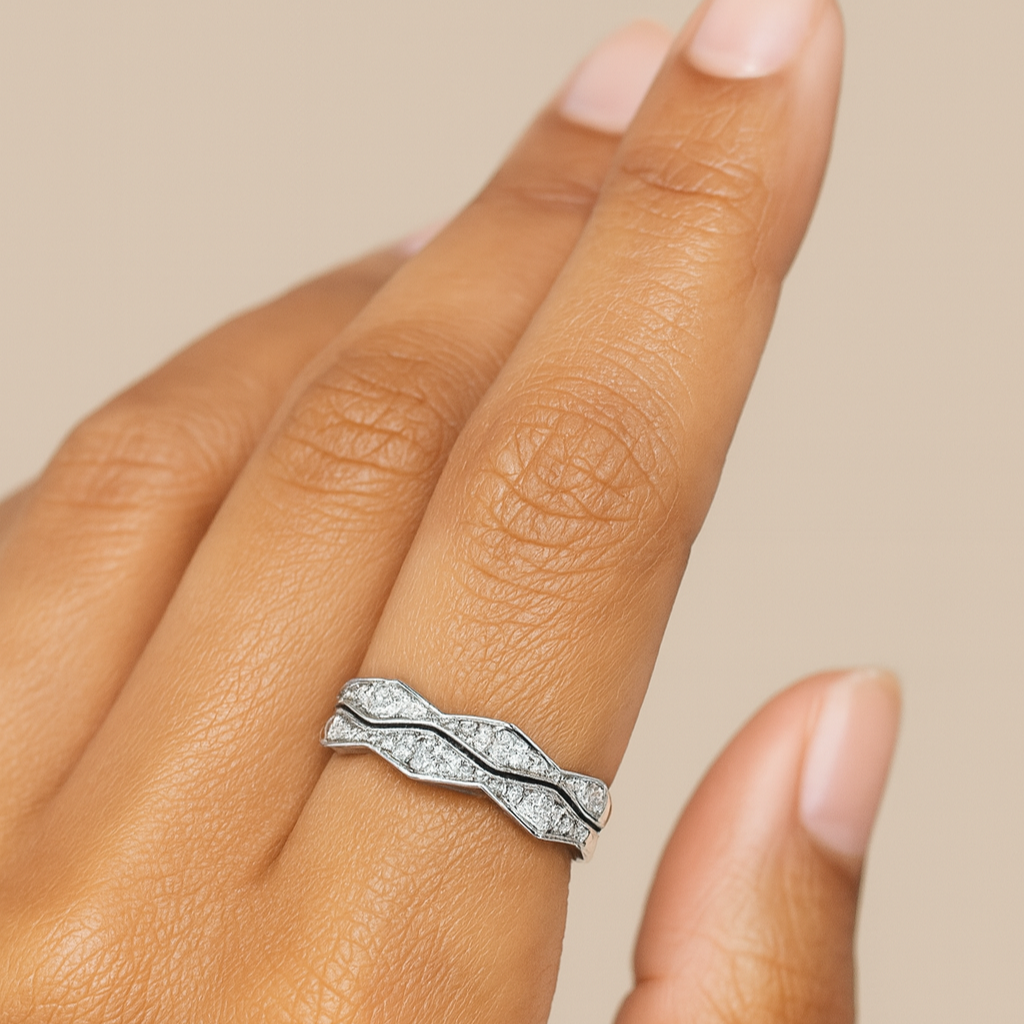 Silver ring with diamond accents on a finger against a beige background