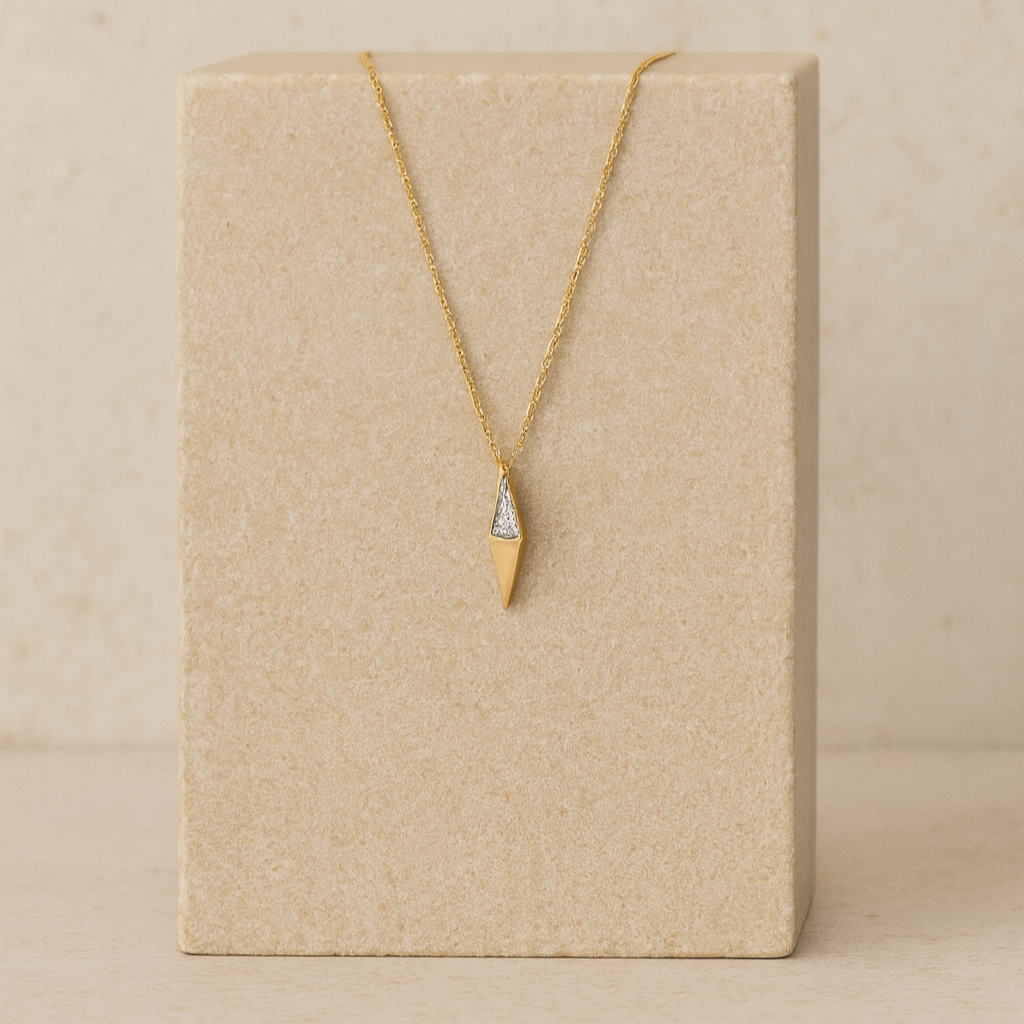 Gold necklace with a pendant on a beige card