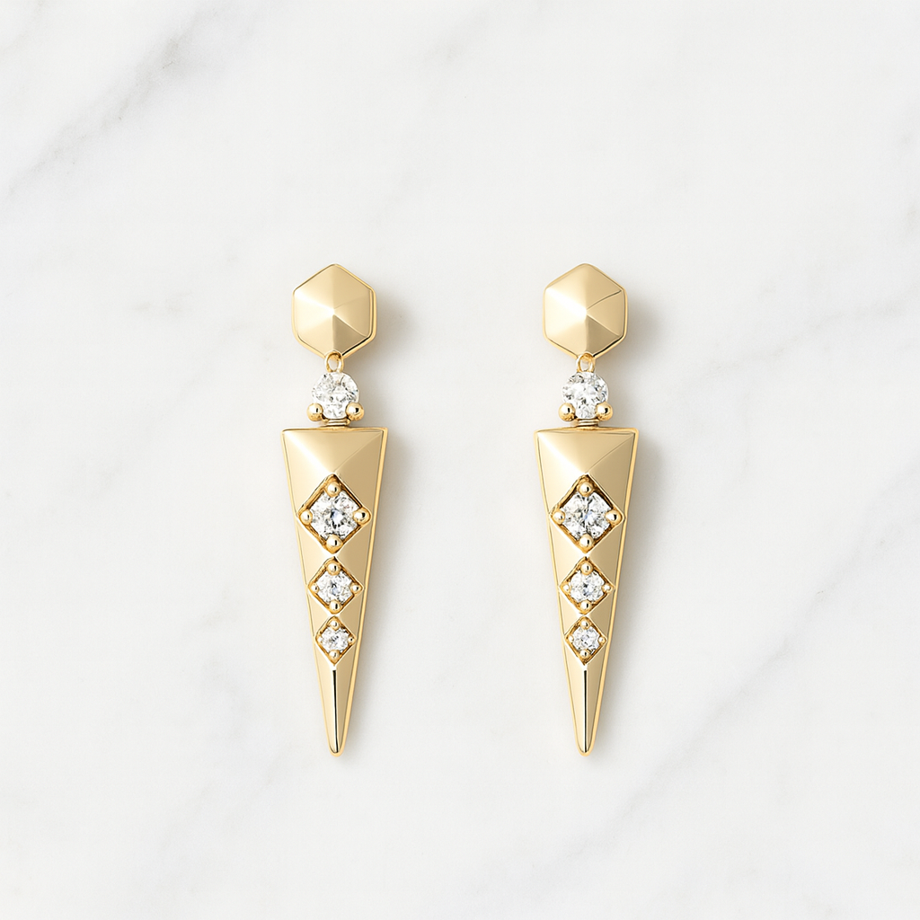 Gold earrings with diamond-like stones on a light gray background