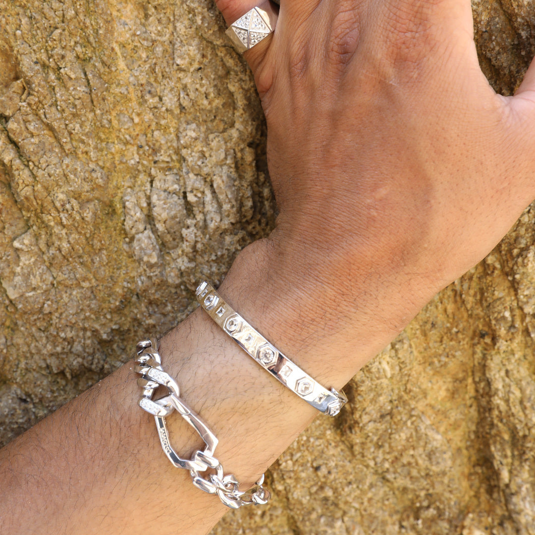 Sterling silver gemstone bracelets on wrist against rock background.