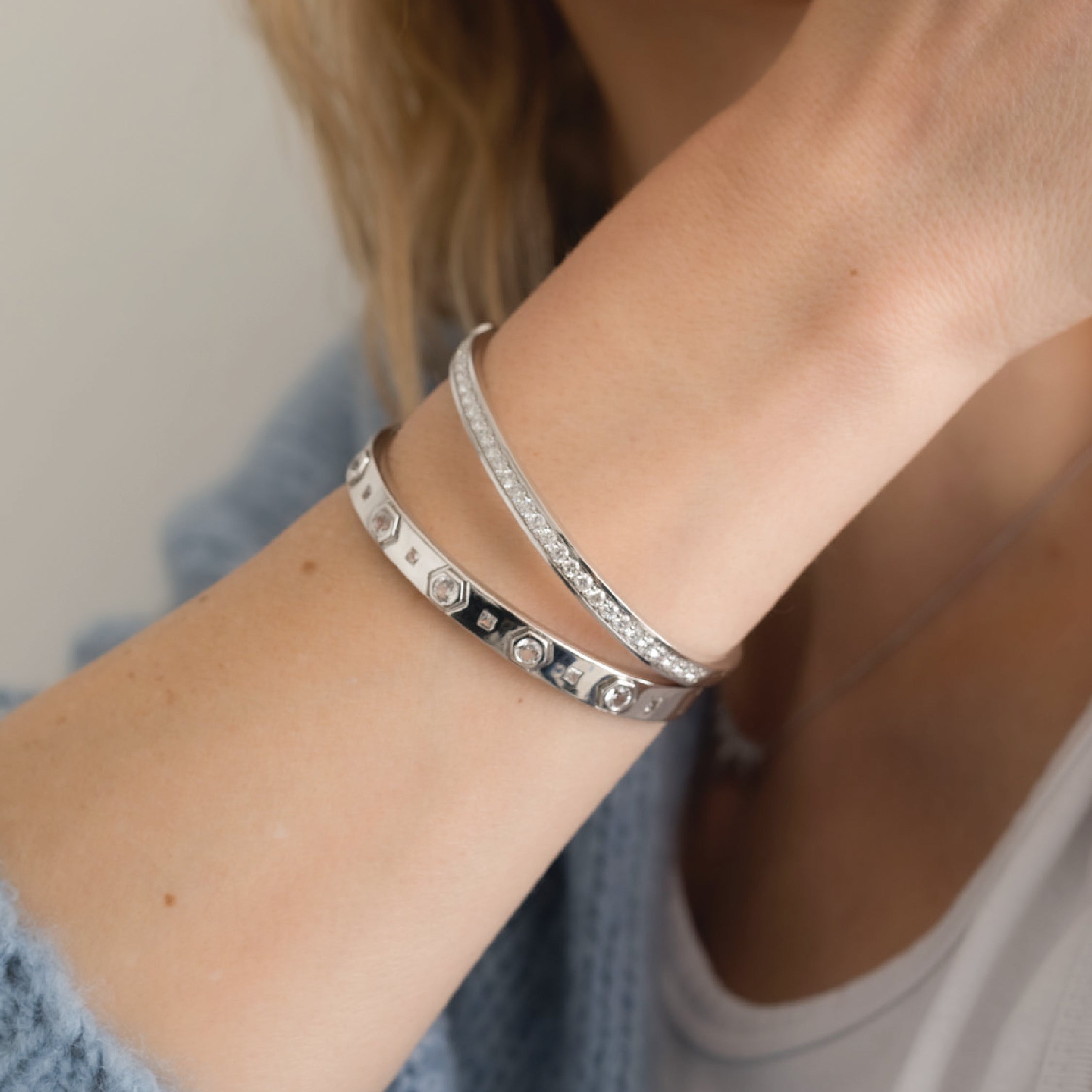 Sterling silver bangle bracelet with gemstones on a wrist, elegant and modern design.